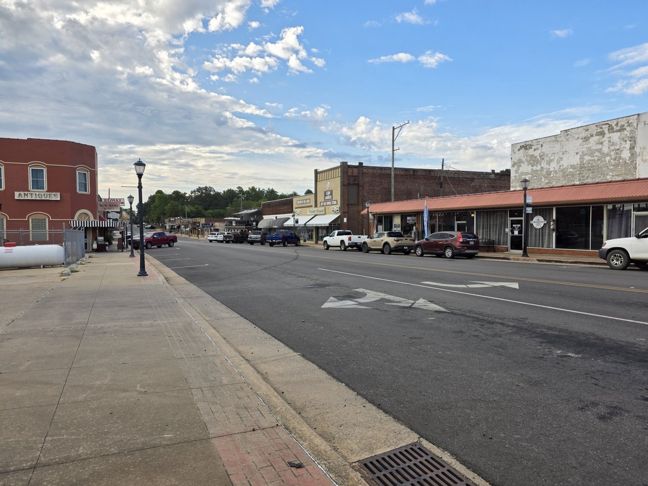 Street and sidewalks lined with downtown Mena businesses.